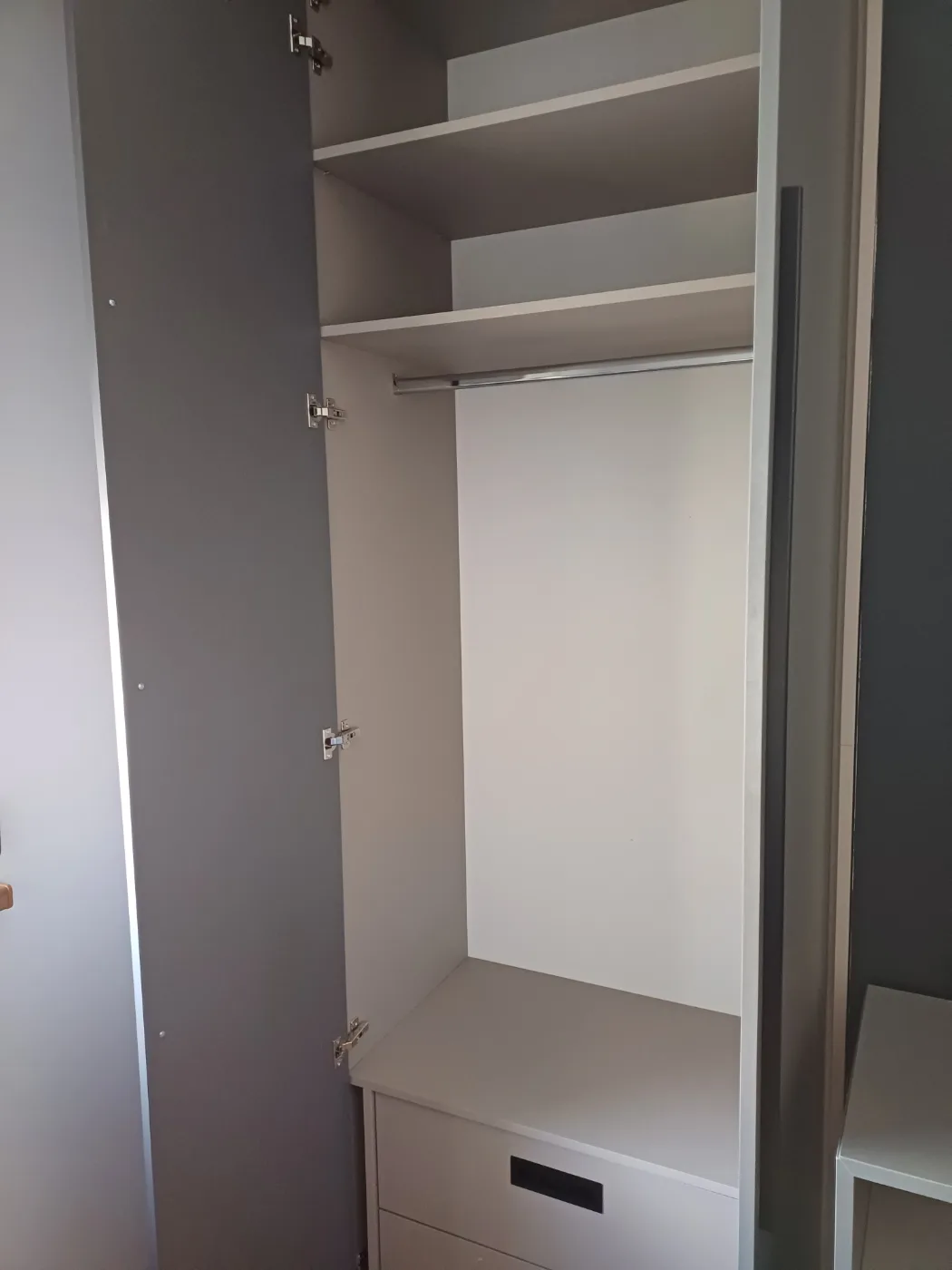 Unutrašnjost garderobe sa šipkom za vješalice i bočnim policama