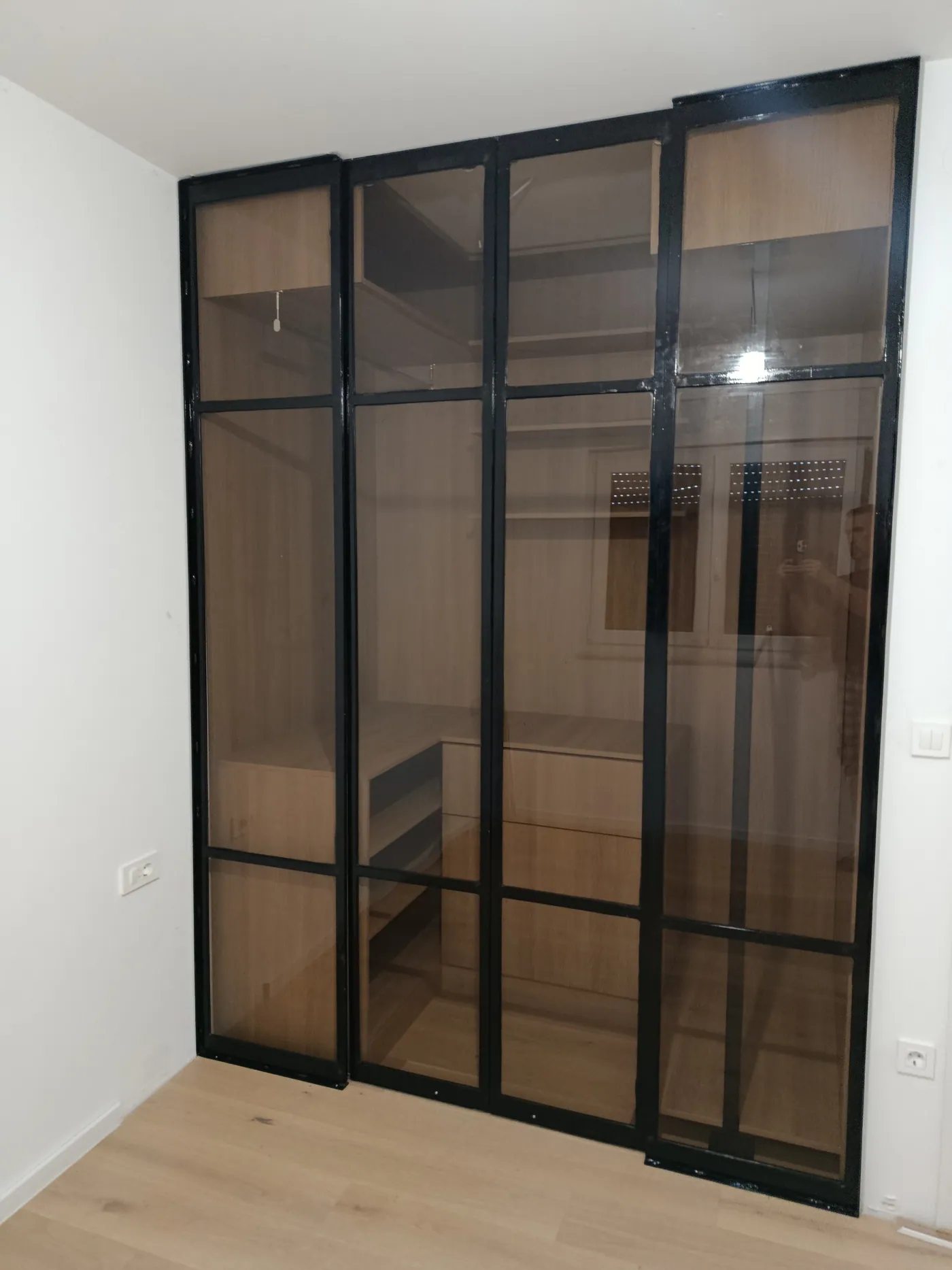 Klizna vrata walk-in garderobe od crnih željeznih profila i prozirnog stakla